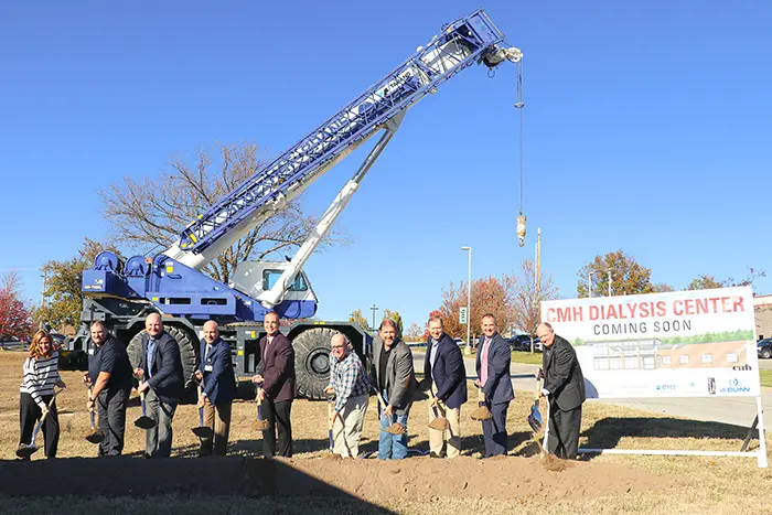 People turning dirt with a shovel